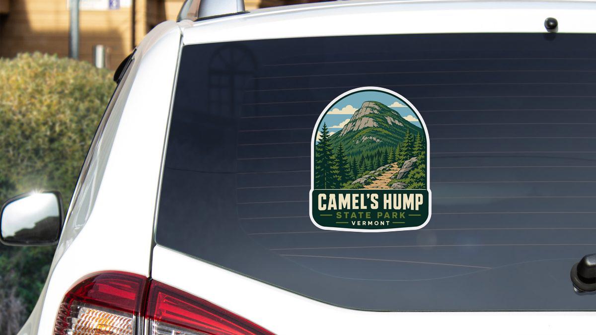 A sticker on the rear window of a white car that says "Camel's Hump State Park Vermont".