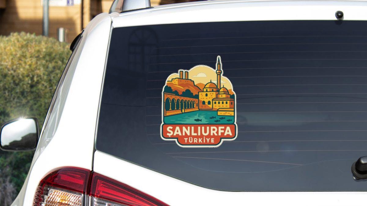 A sticker on the rear window of a car, depicting a cityscape with a mosque in the background.