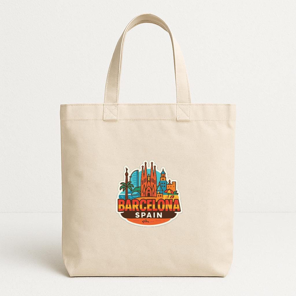 A beige tote bag with a printed design of the city of Barcelona, Spain, featuring various landmarks and buildings.