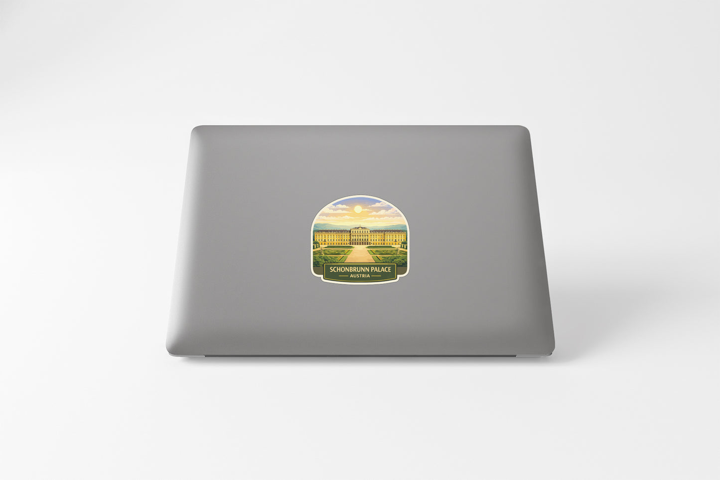 a grey laptop with a sticker depicting a palace on its back cover.
