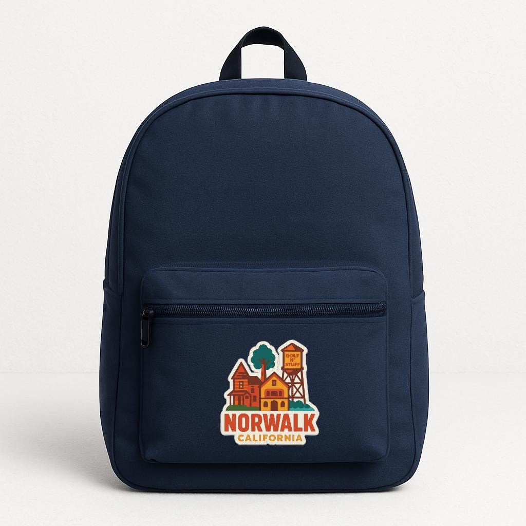 A navy blue backpack with a graphic of a town and the text "NORWALK CALIFORNIA" printed on it.