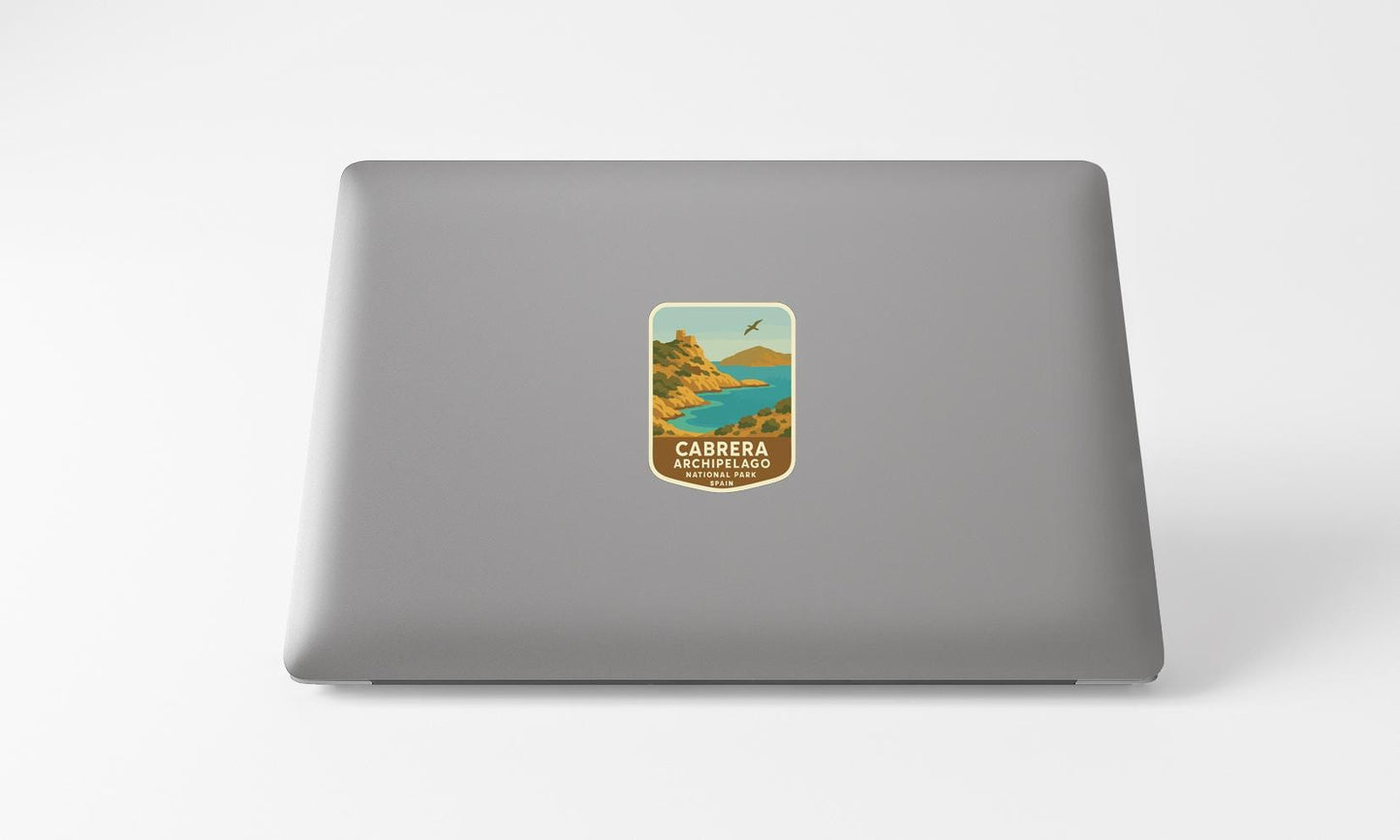 a sticker on the back of a laptop, depicting a scenic landscape with mountains, a lake, and a bird in flight.