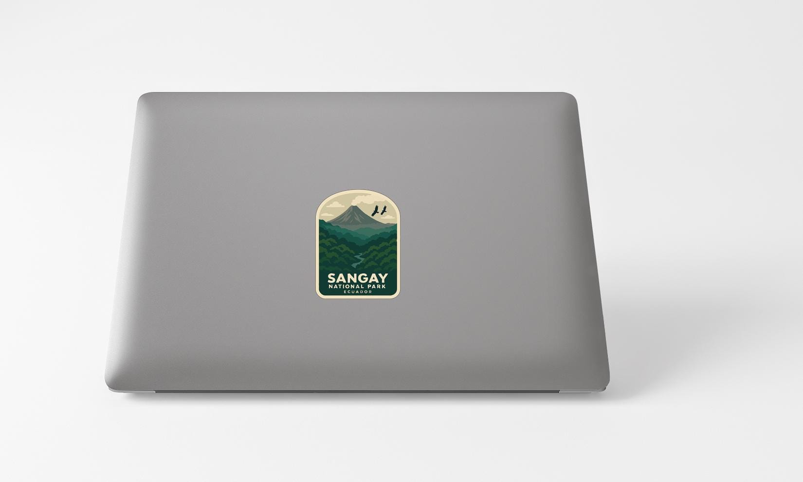 A sticker with a mountain landscape and the text "Sangay National Park" printed on a grey laptop.