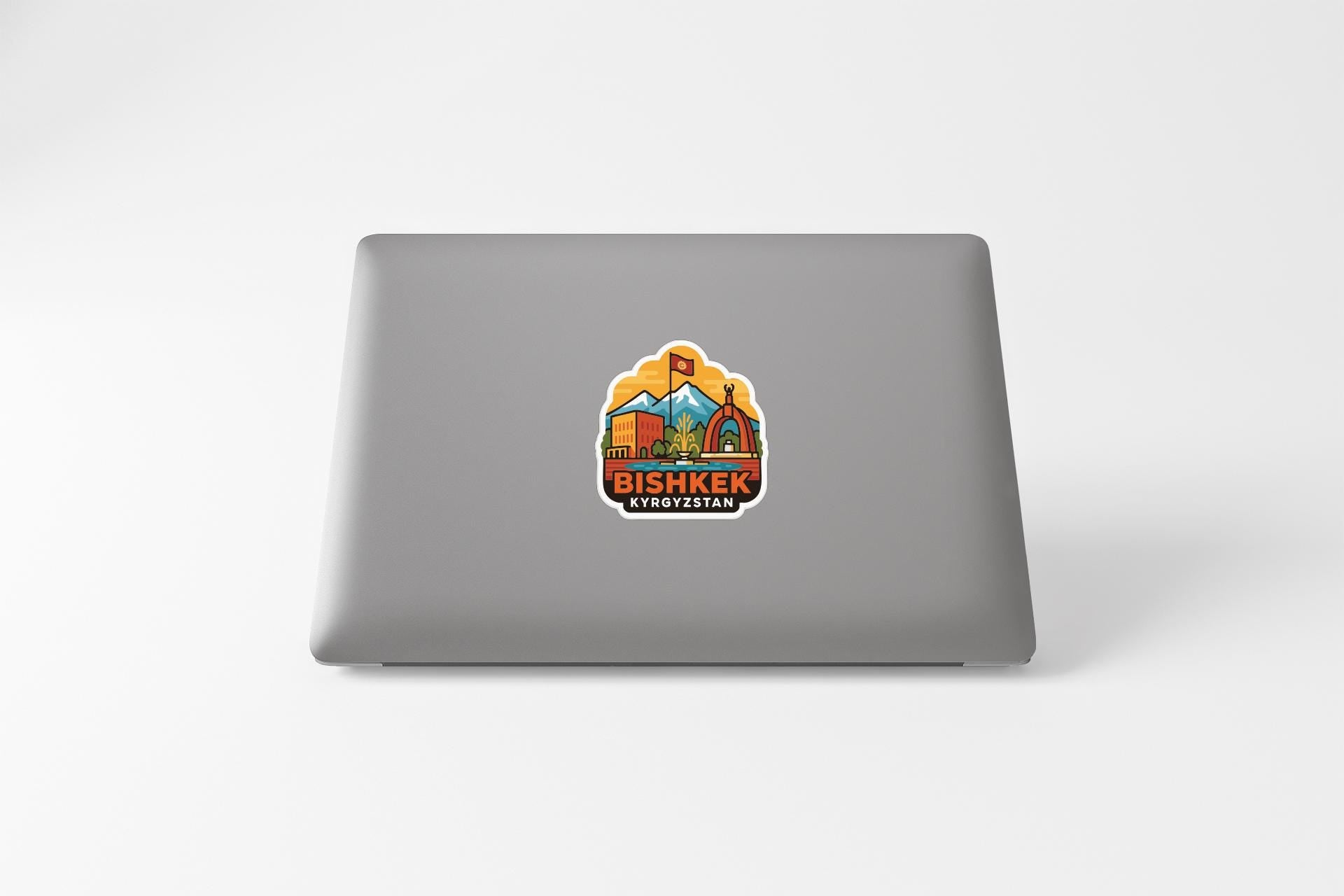 a sticker on the back of a laptop with an illustration of a mountain and a flag.