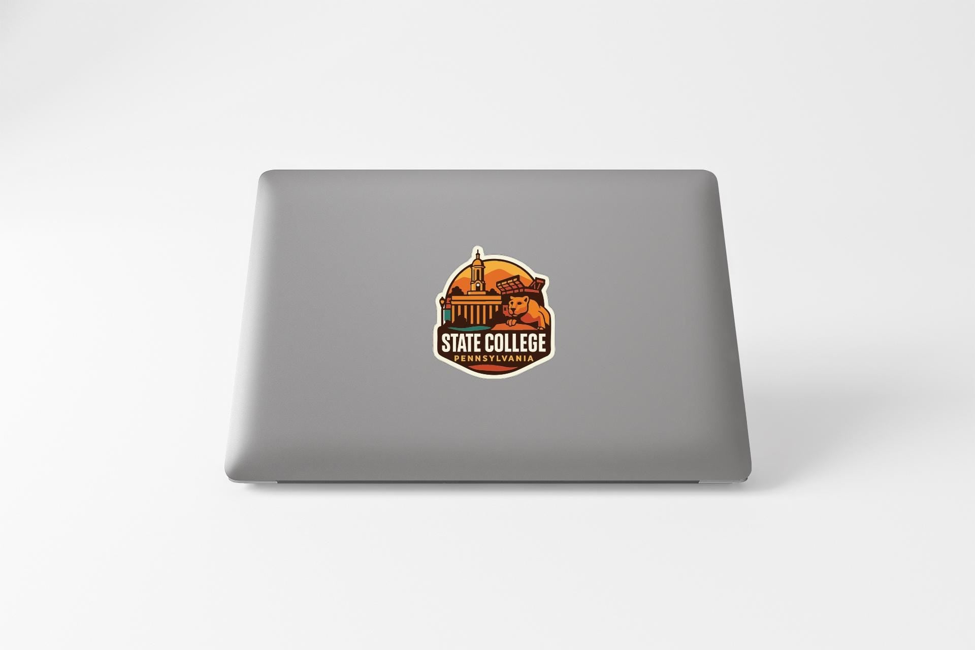 a sticker with a graphic of a building and the text "STATE COLLEGE" on the back of a laptop.