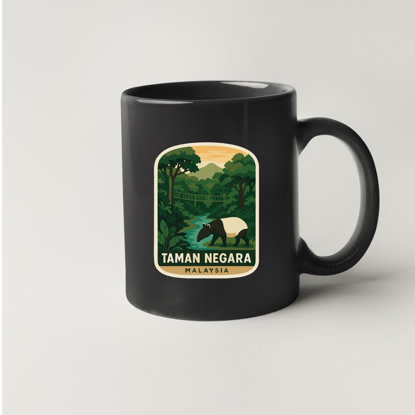A black coffee mug with a sticker depicting a scenic landscape of Taman Negara, Malaysia.