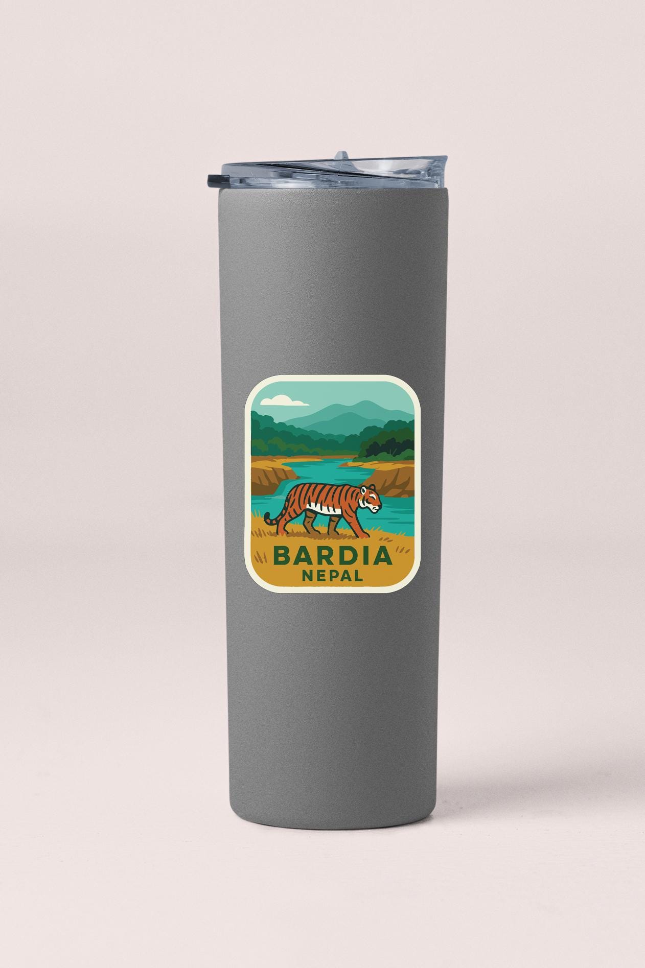 A gray tumbler with a sticker depicting a tiger in a natural landscape, along with the text "Bardia Nepal".