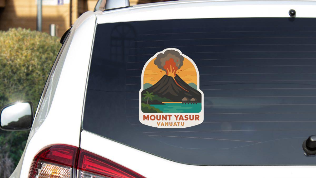A sticker on the rear window of a car that features a stylized illustration of a volcano with a tropical island in the background.