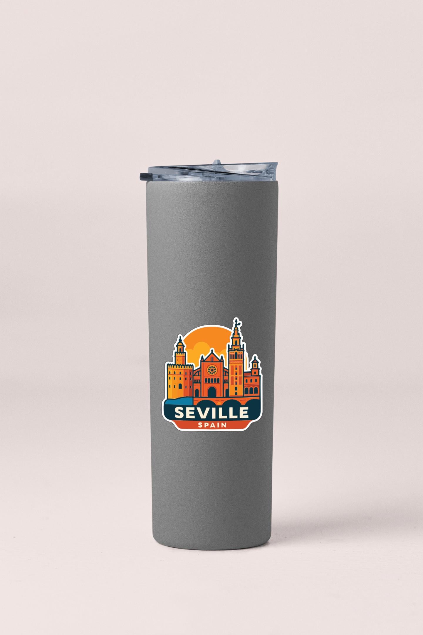 A gray insulated tumbler with a printed sticker depicting the city of Seville, Spain.