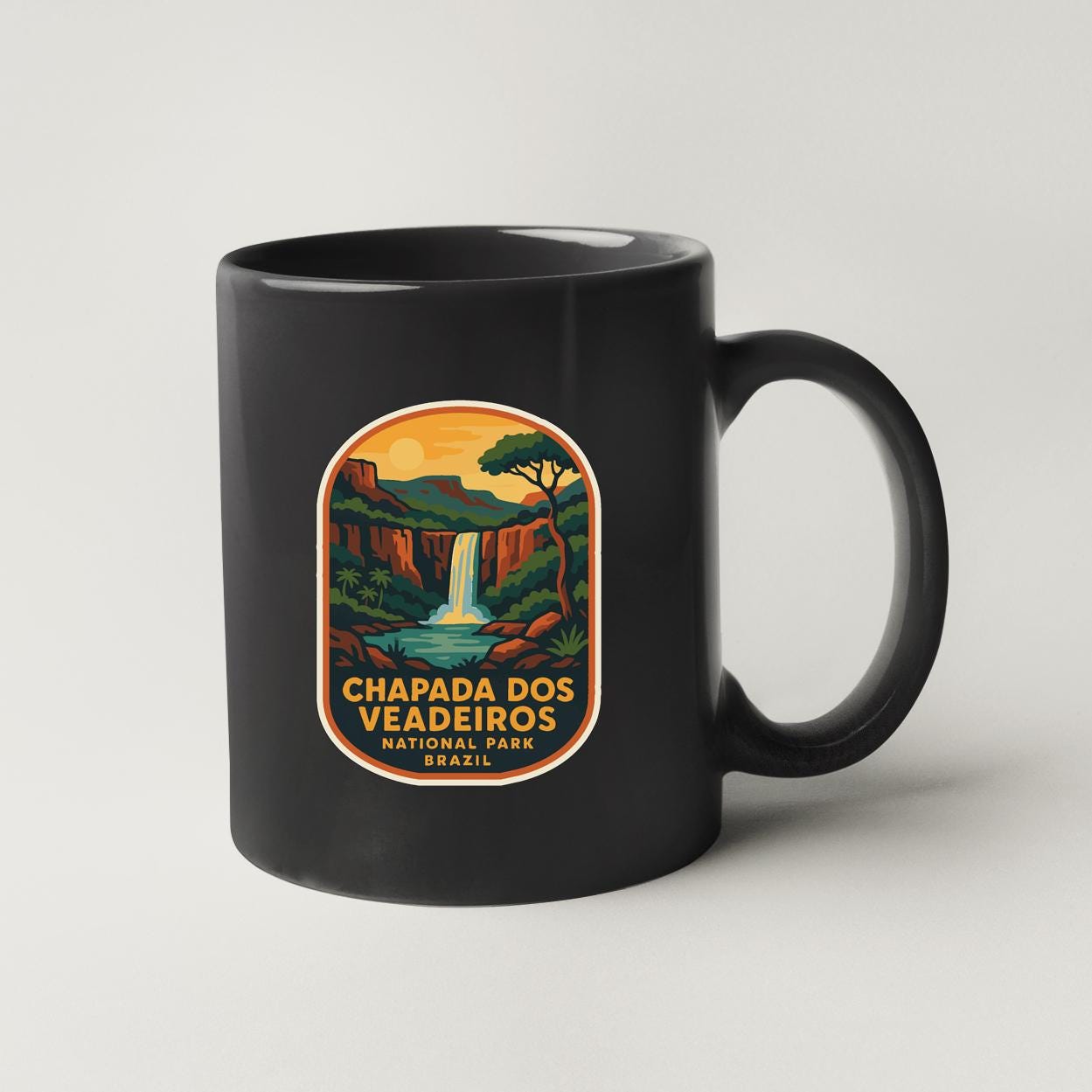 A black coffee mug with a colorful label that says "CHAPADA DOS VEGADEIROS NATIONAL PARK BRASIL".