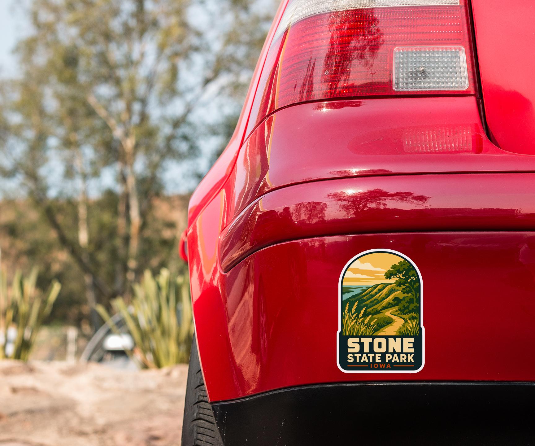 the rear end of a red car with a sticker on the back window that says "STONE STATE PARK IOWA".