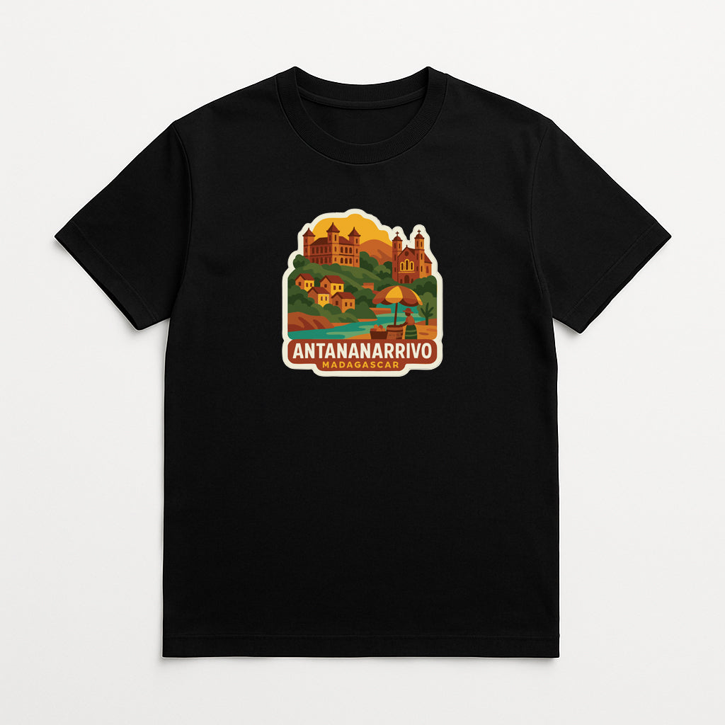 A black t-shirt with a colorful graphic design depicting a scenic landscape with buildings, a castle, and a beach.