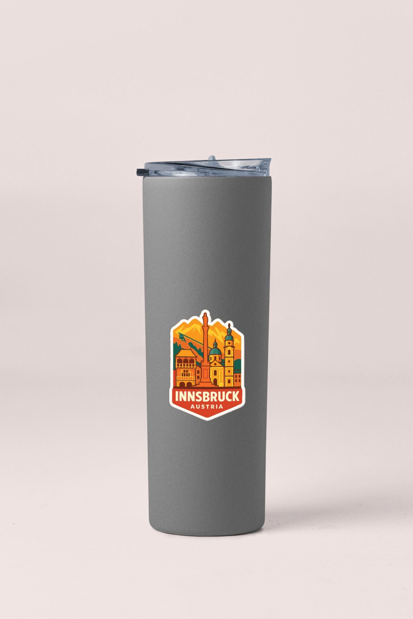 A gray insulated tumbler with a logo featuring a city skyline and the text "INNSBRUCK AUSTRIA" printed on it.