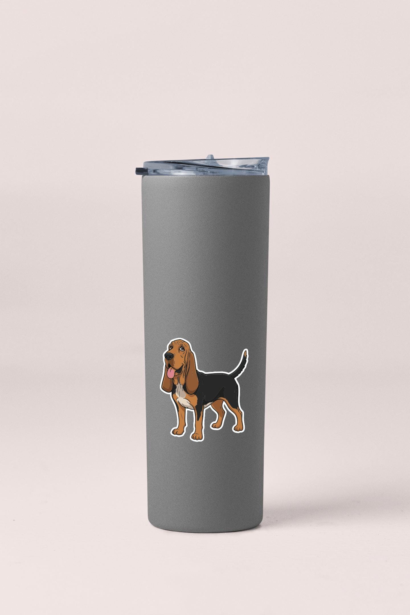 A gray insulated tumbler with a sticker of a dog on it.