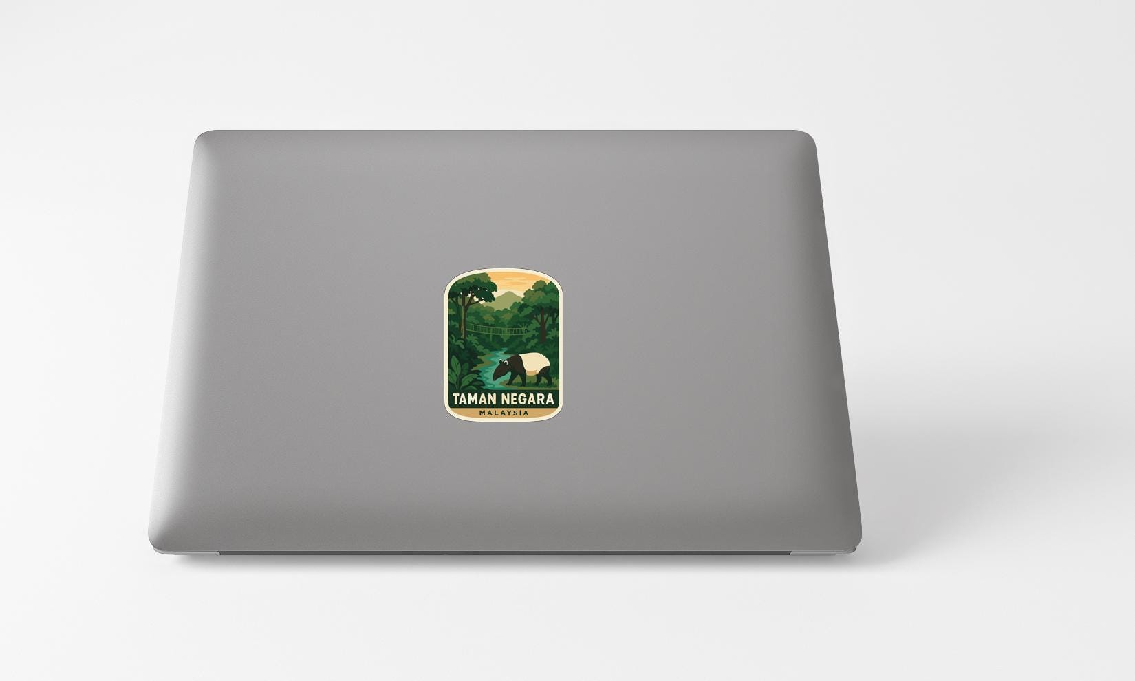 A sticker with a tropical landscape on a laptop.