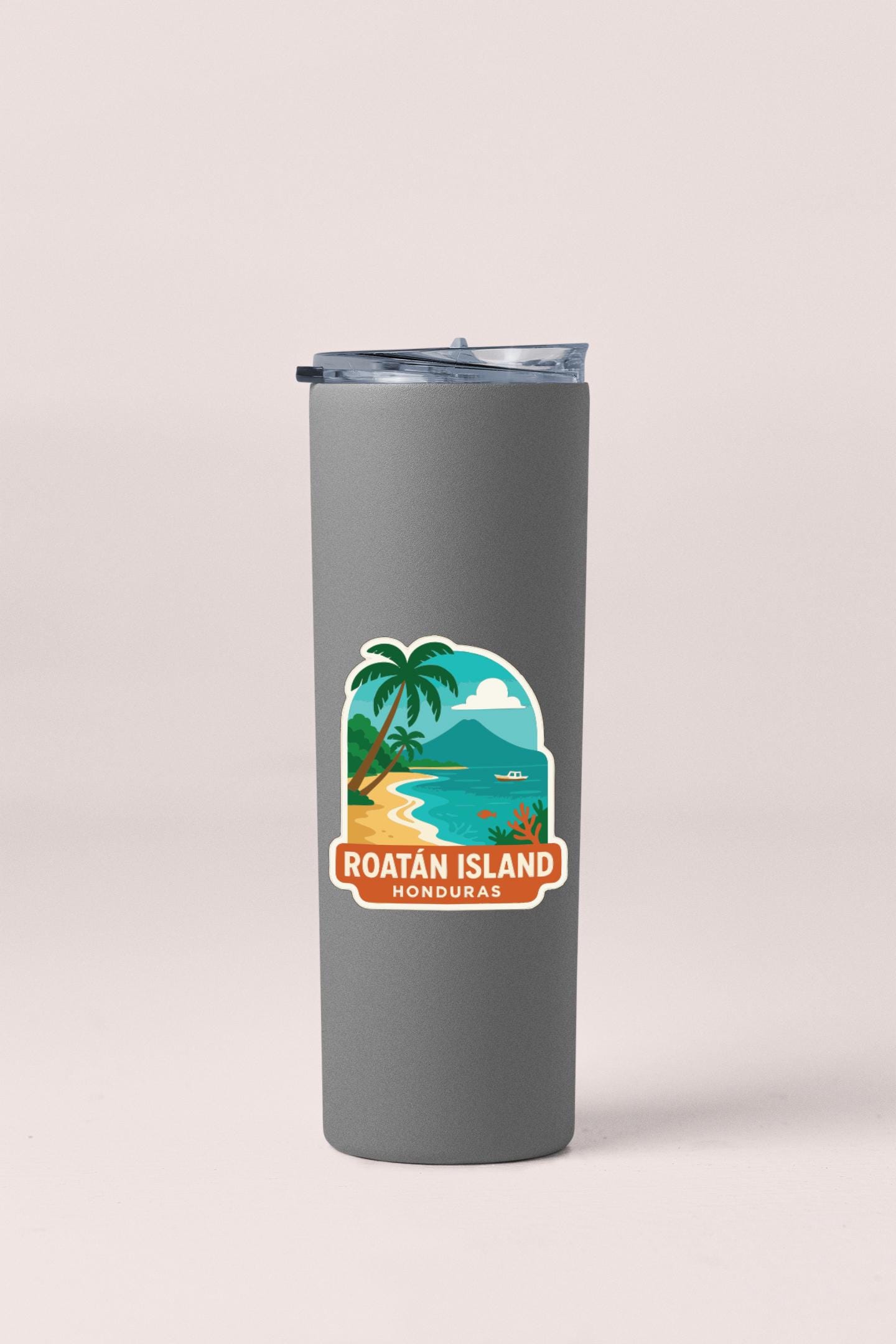 A gray insulated tumbler with a sticker depicting a tropical beach scene and palm trees.