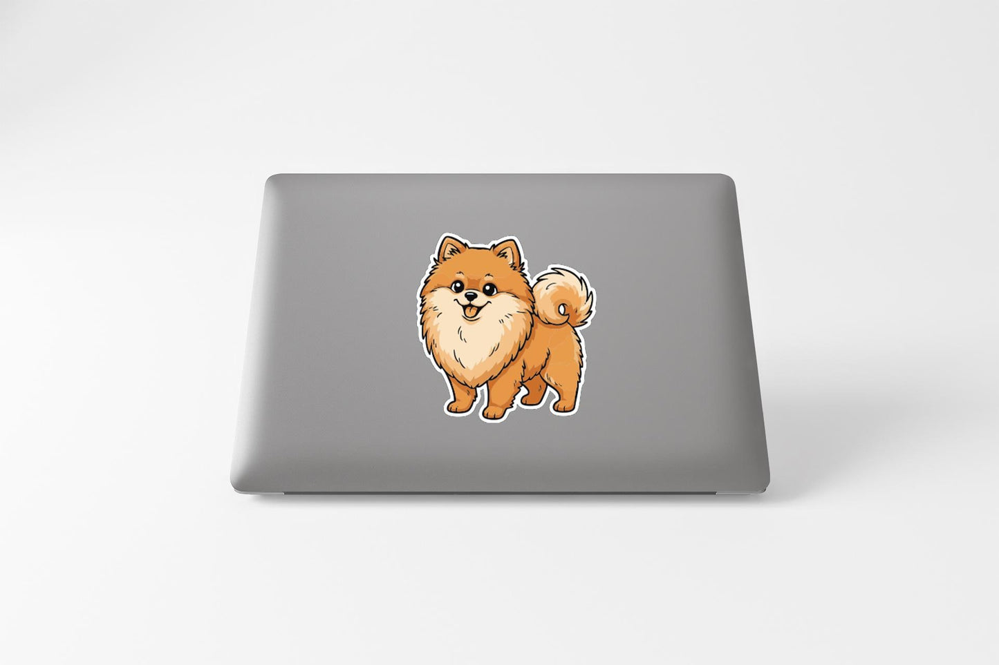 A sticker of a Pomeranian dog on the back of a laptop computer.