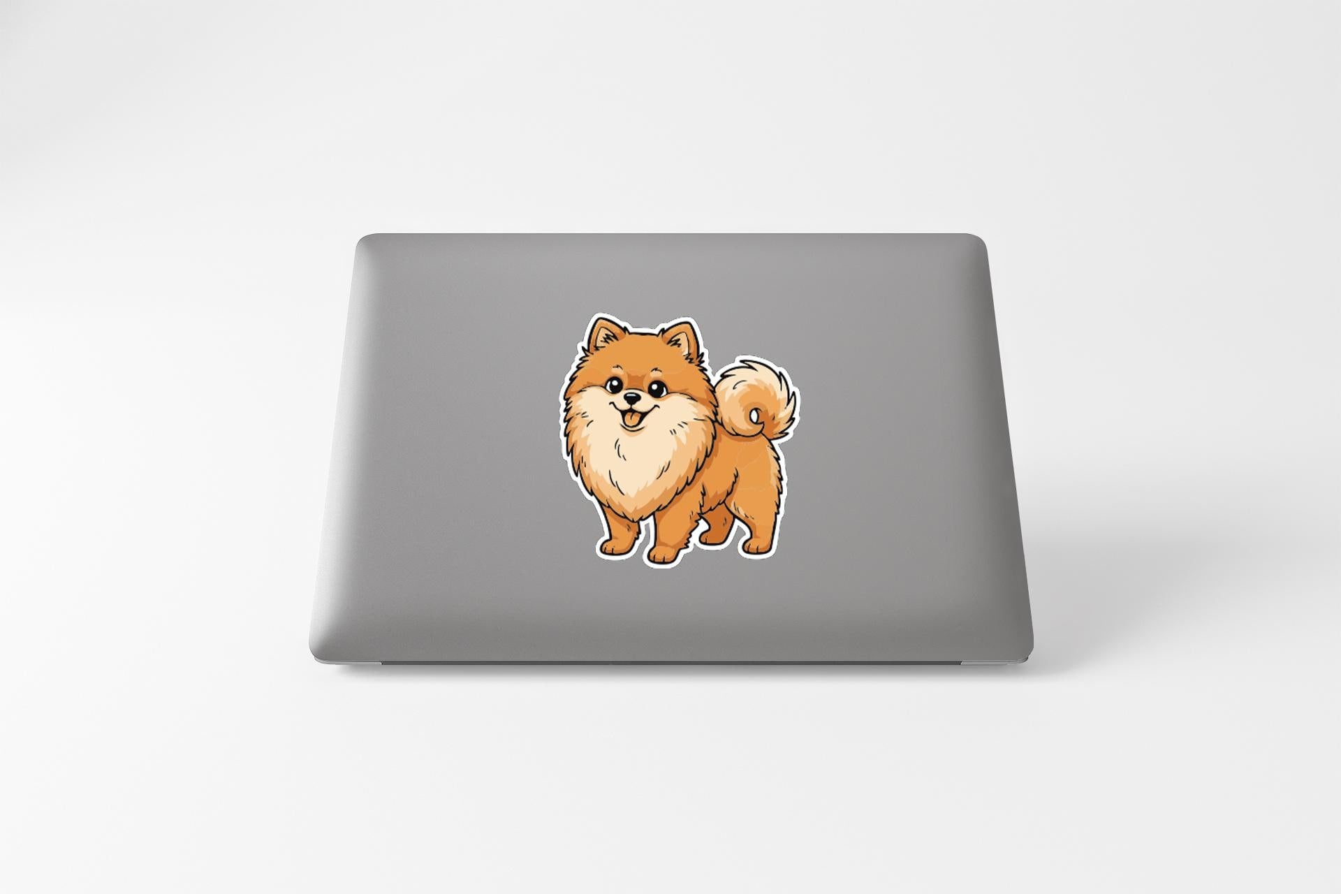 A sticker of a Pomeranian dog on the back of a laptop computer.