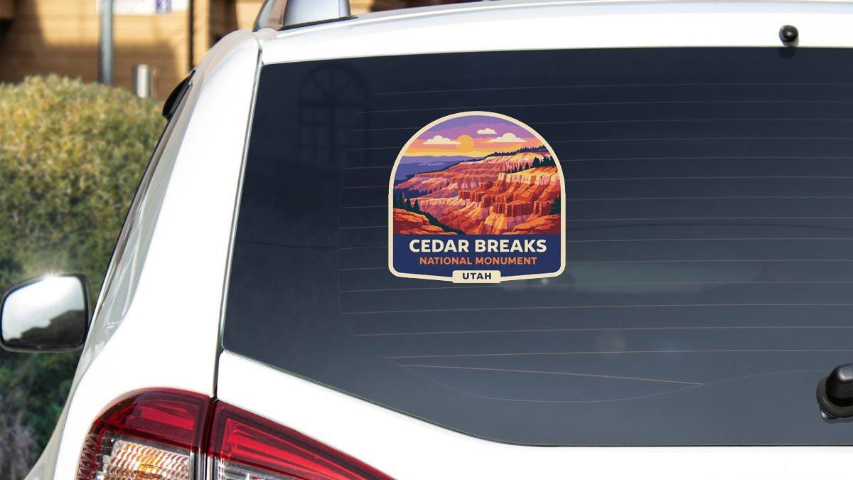 A sticker on the rear window of a car that says "Cedar Breaks NATIONAL MONUMENT UTAH".