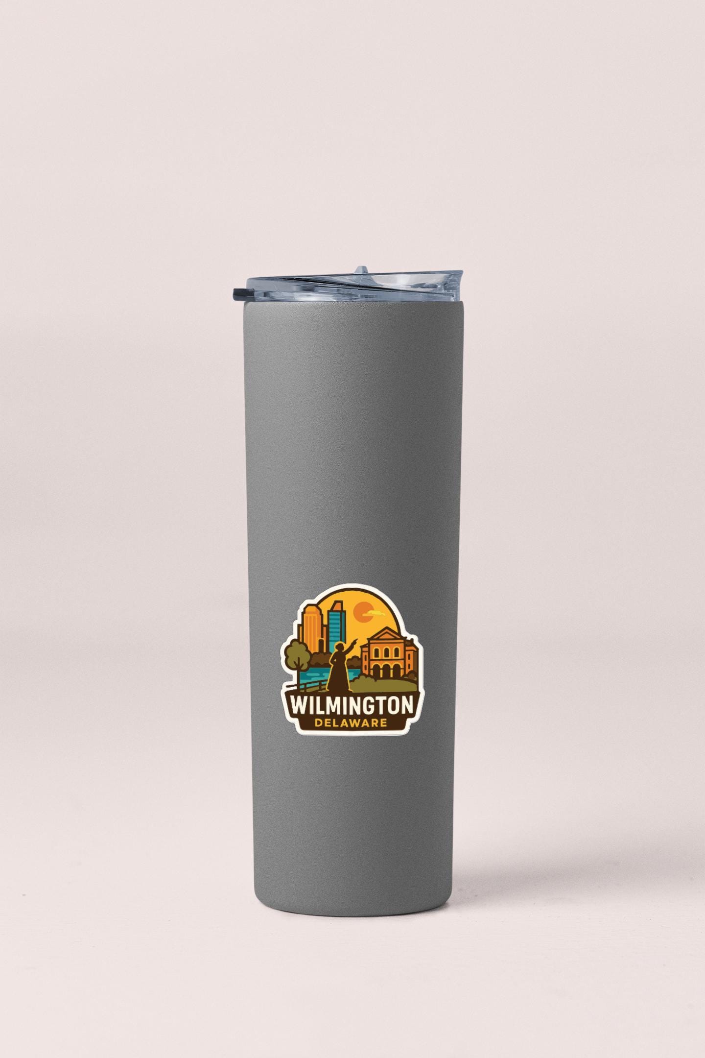 A gray insulated tumbler with a sticker depicting a city skyline and the text "Wilmington, North Carolina".