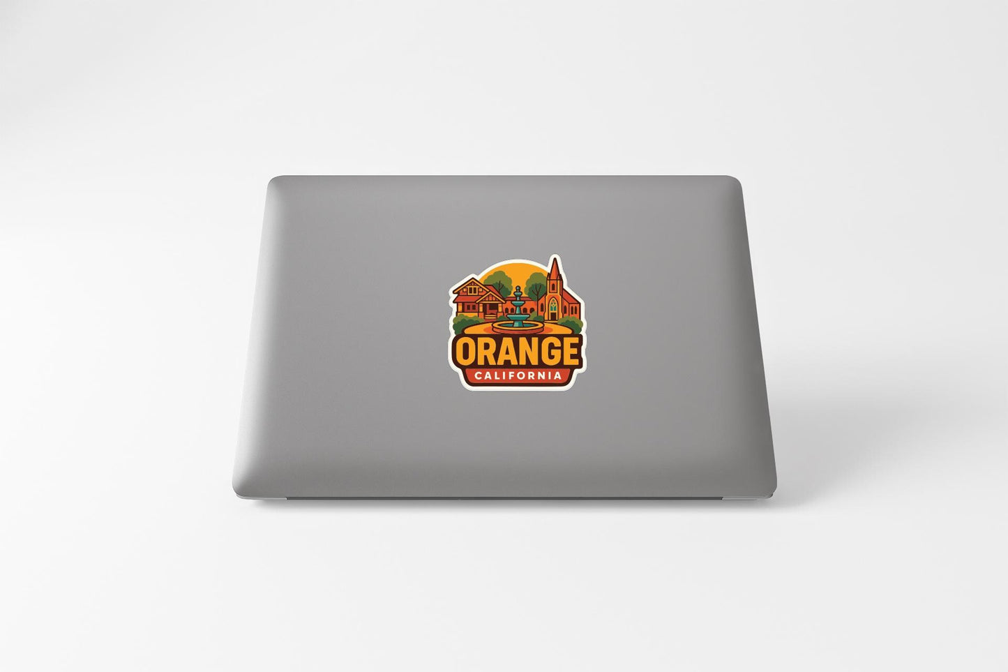 a sticker with a graphic of a city and the text "Orange California" on a laptop.