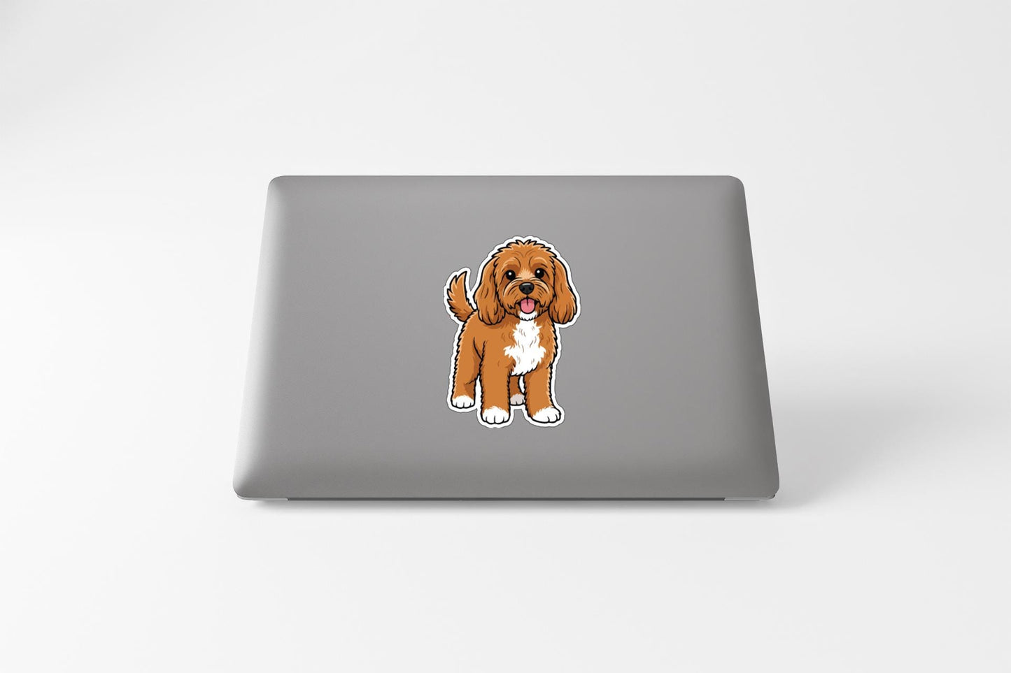 A sticker of a brown and white dog on the back of a laptop computer.