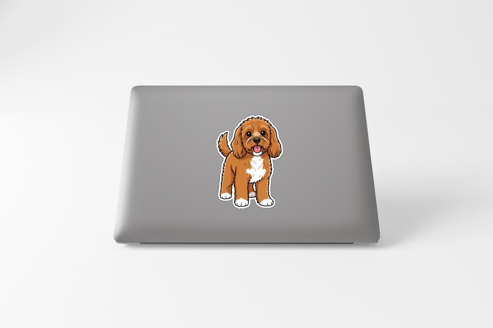A sticker of a brown and white dog on the back of a laptop computer.