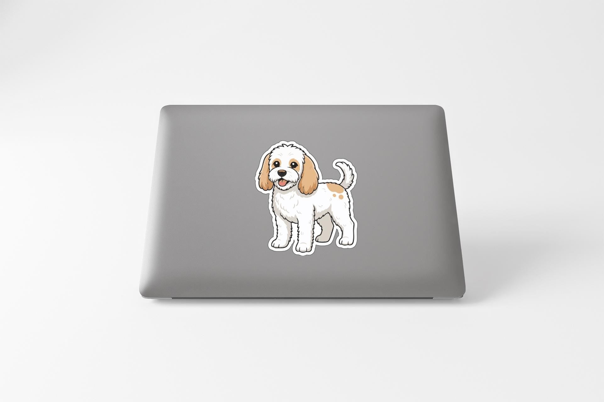 A sticker of a cartoon dog is on the back of a laptop.
