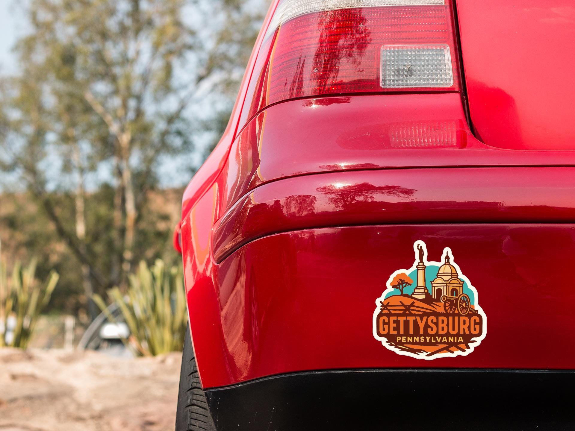 the rear end of a red car with a sticker on the trunk that says "GETTYSBURG, PA".