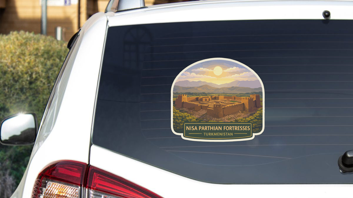 A sticker on the rear window of a car, depicting a desert landscape with a castle or fortification in the foreground.