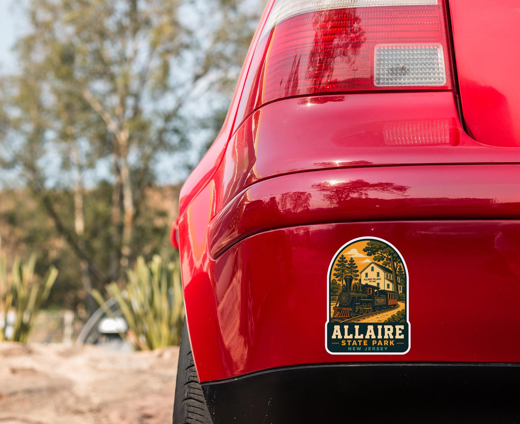the rear end of a red car with a sticker on the trunk that says "Allaire State Park".