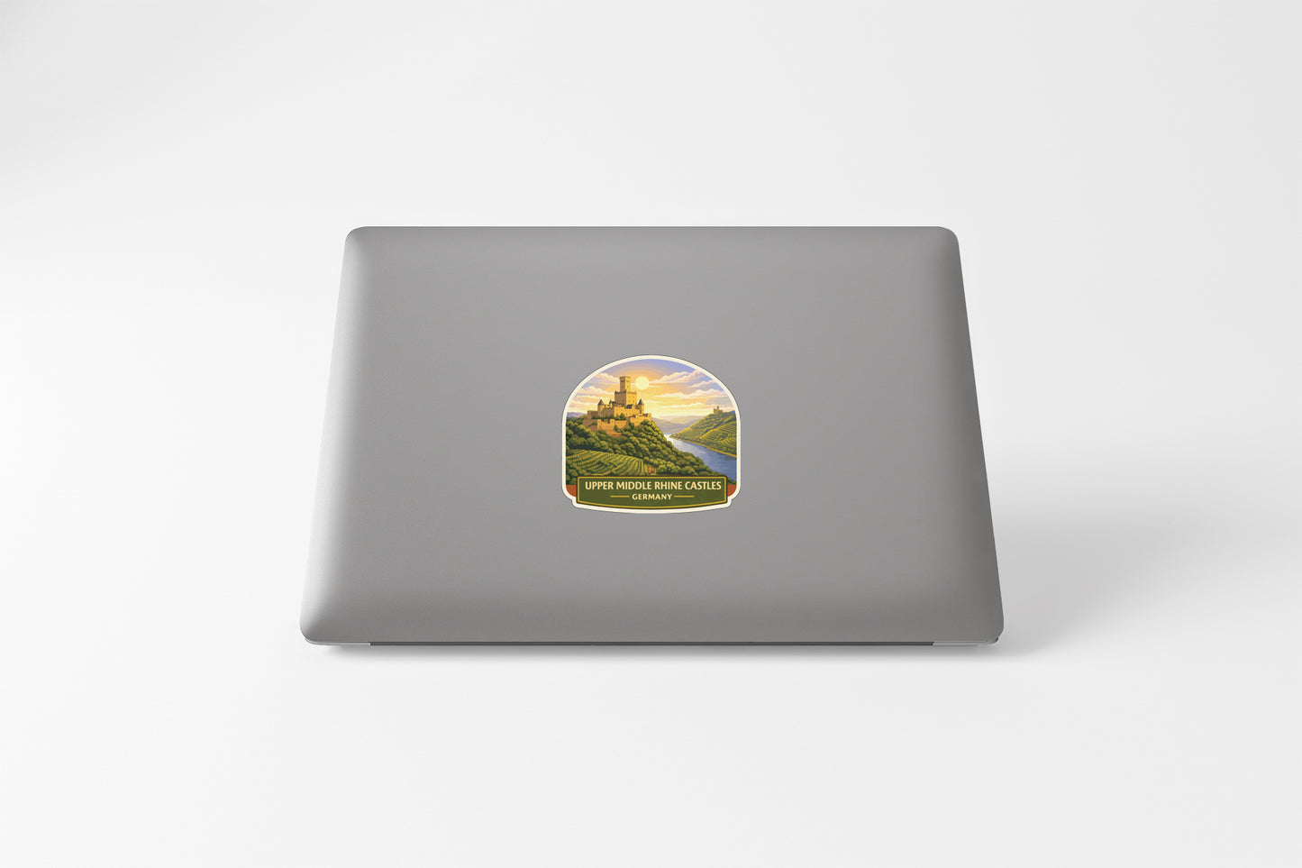 a sticker with a castle on a hill, and the sticker is placed on the back of a laptop.