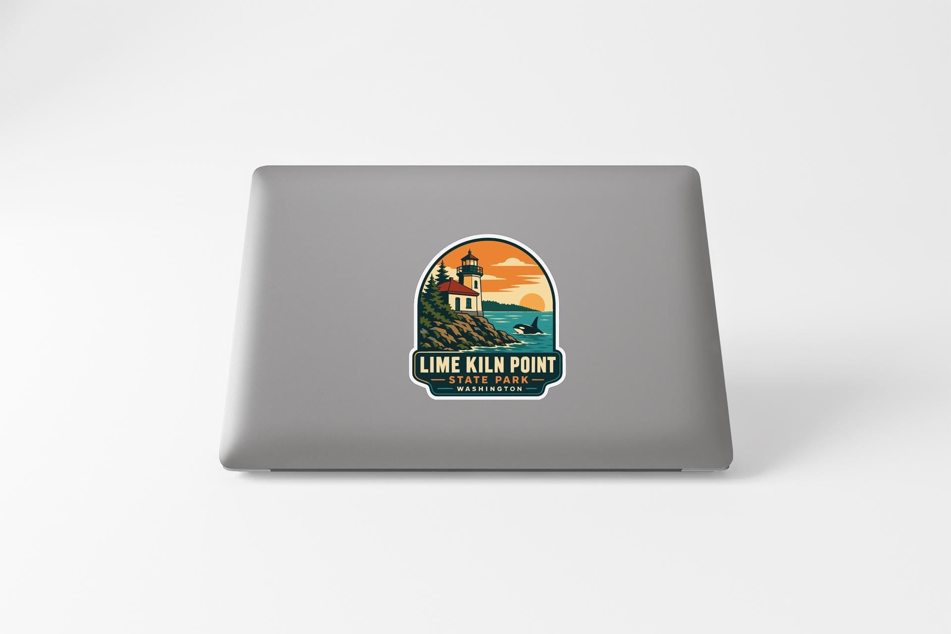 a sticker with a lighthouse and a sunset on a laptop.
