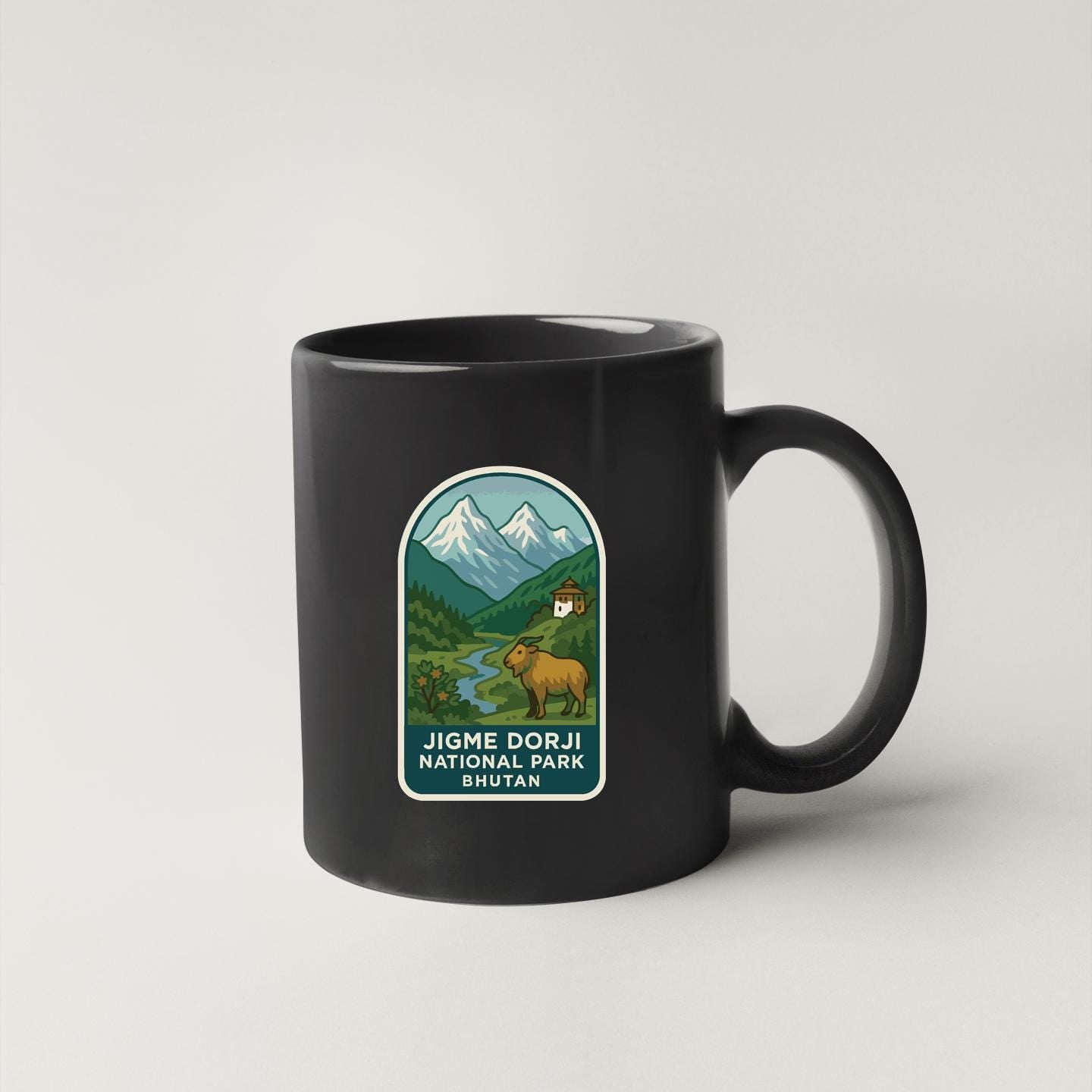 A black coffee mug with a graphic design depicting a mountain landscape and a person riding a horse.