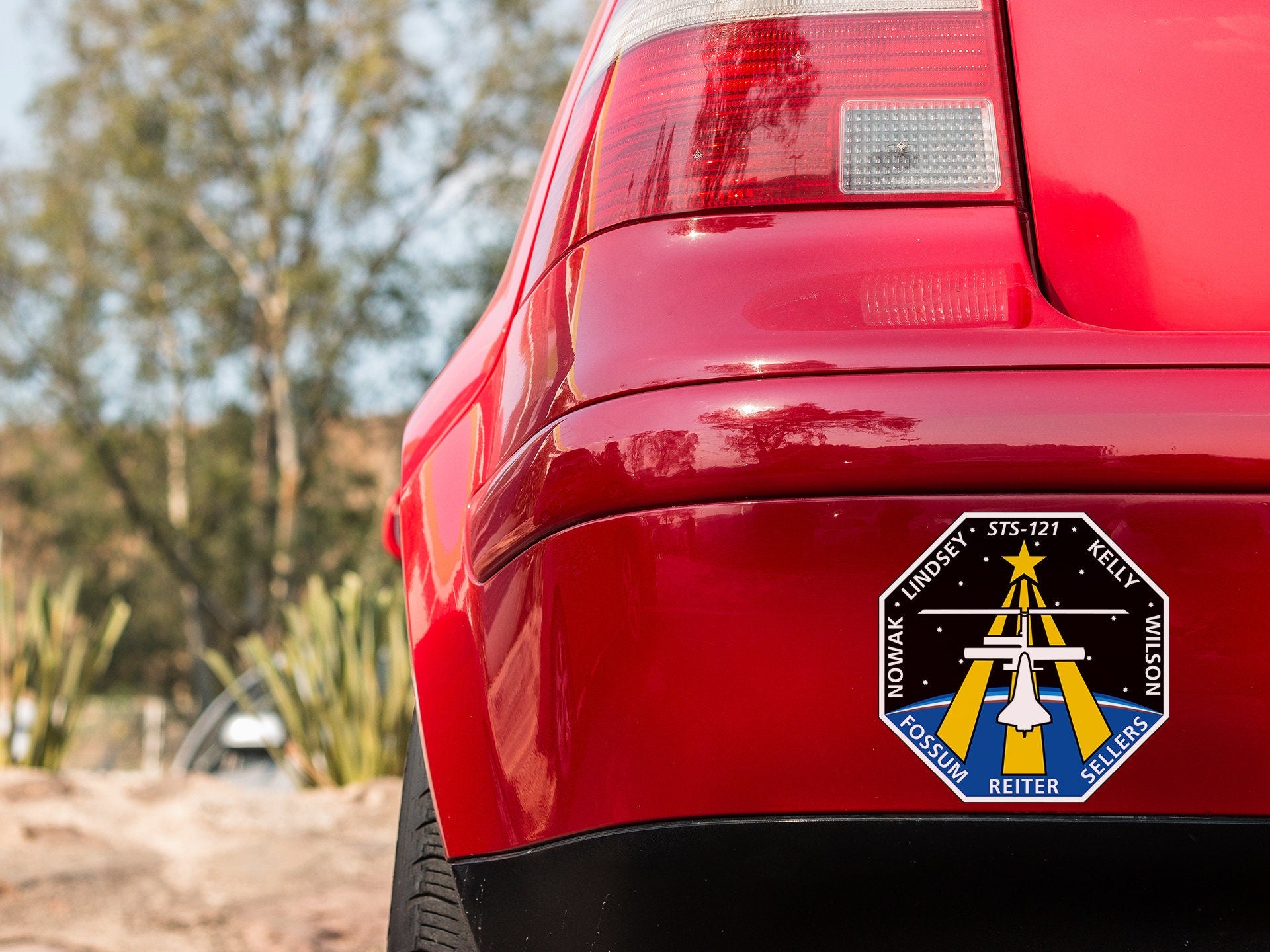 a close up of a red car with a sticker on it