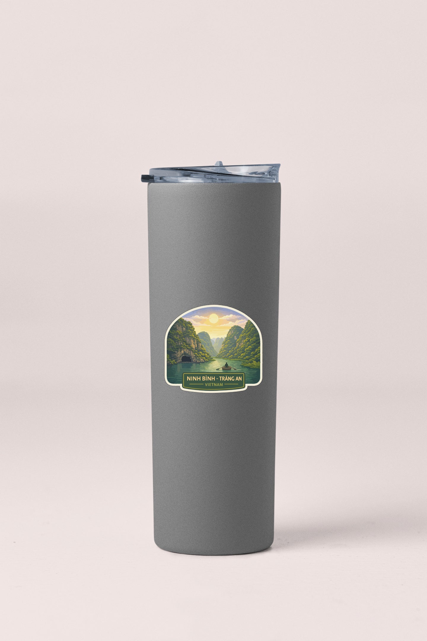 A gray insulated tumbler with a label depicting a scenic landscape.