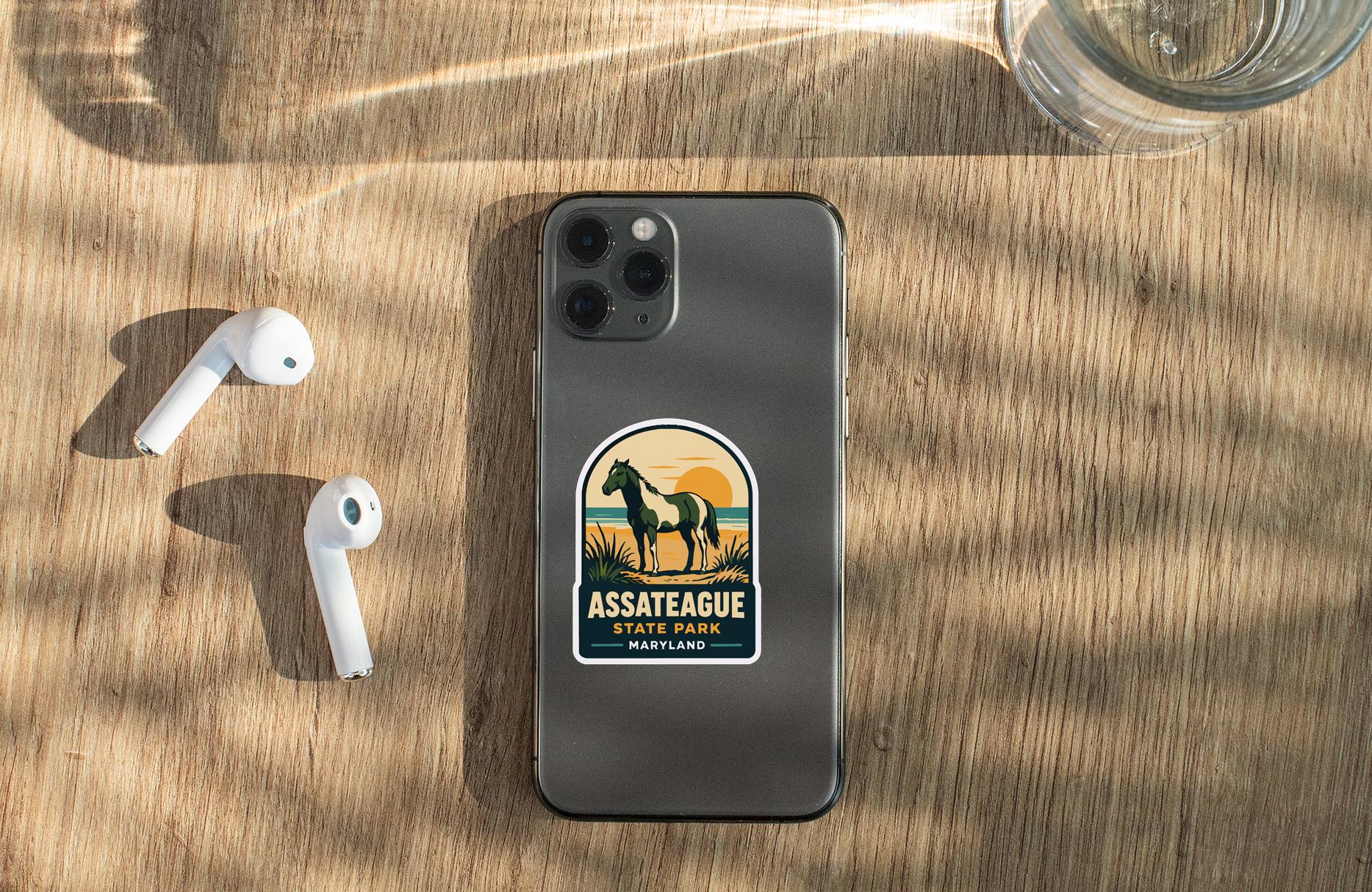 a smartphone with a sticker on the back, placed on a wooden surface alongside a pair of white earbuds and a glass of water.