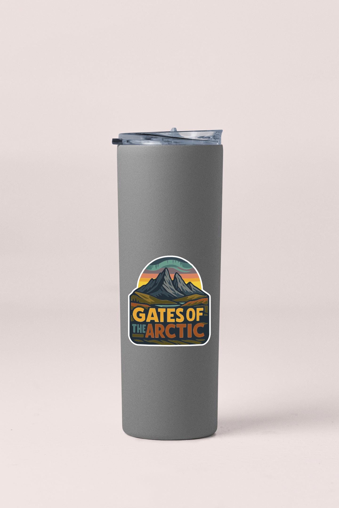 A gray insulated tumbler with a sticker that says "GATES OF THE ARCTIC".