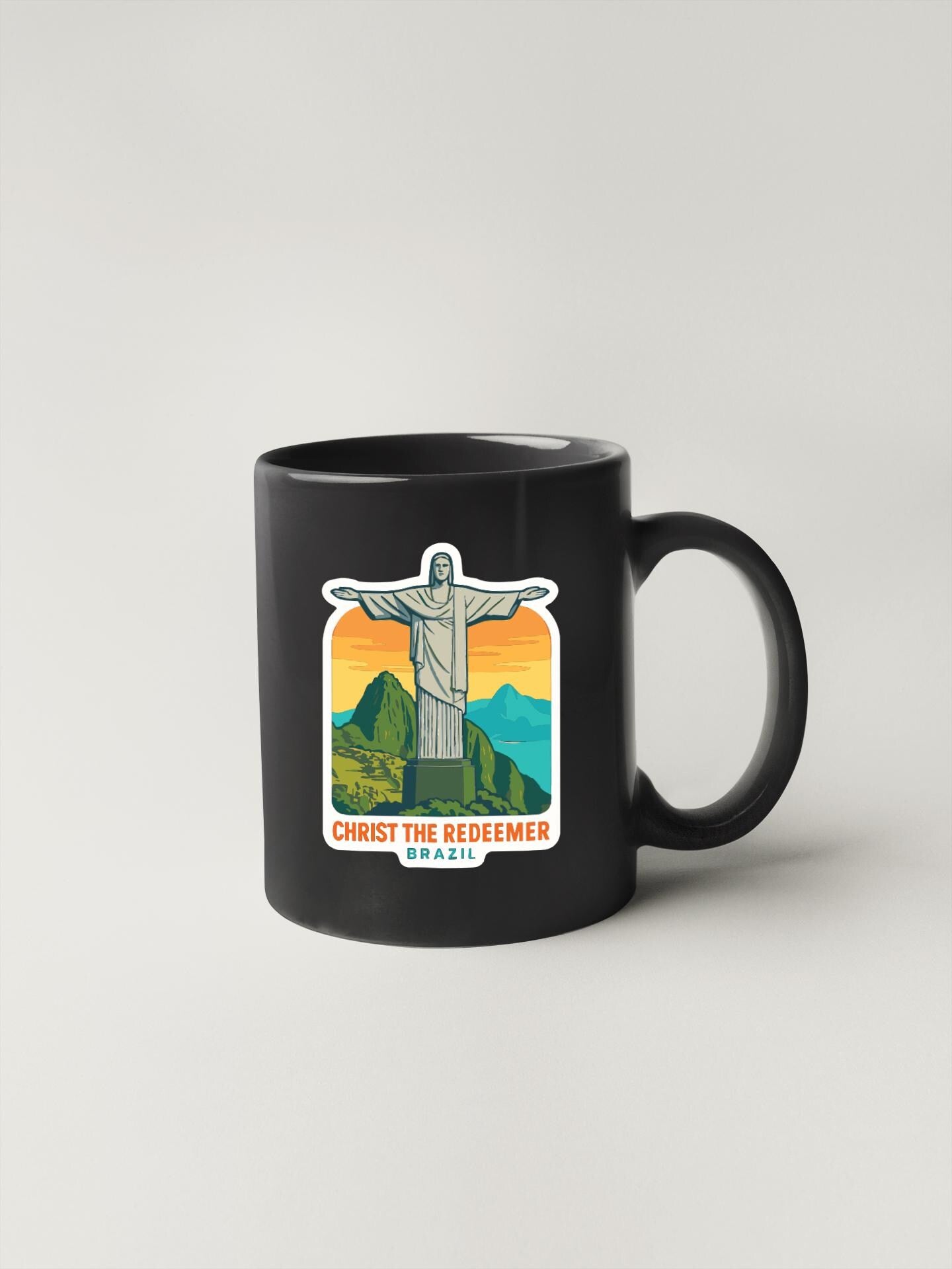 A black coffee mug with a sticker depicting the Christ the Redeemer statue in Brazil.