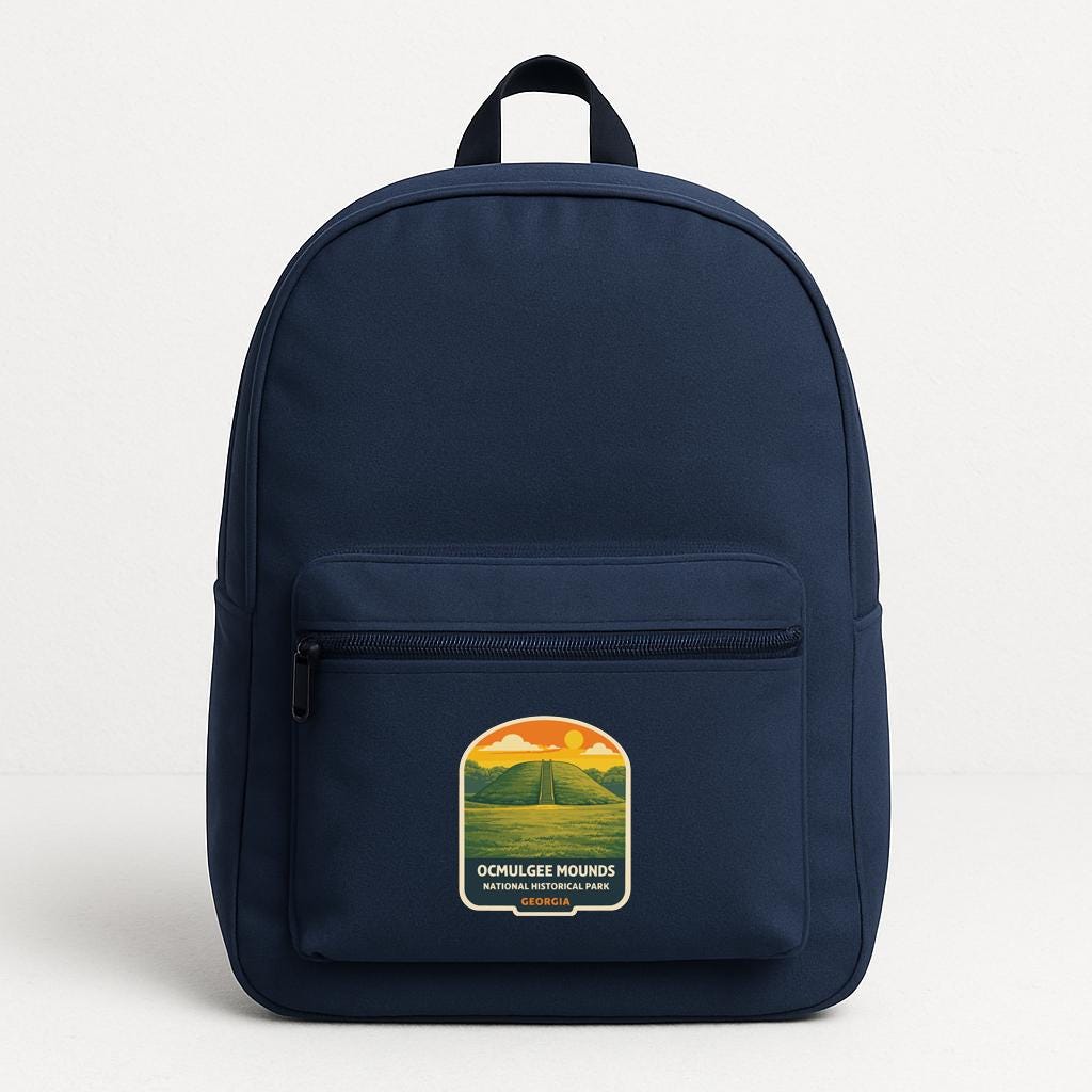 A navy blue backpack with a graphic on the front, depicting a mountain landscape with a sunset.
