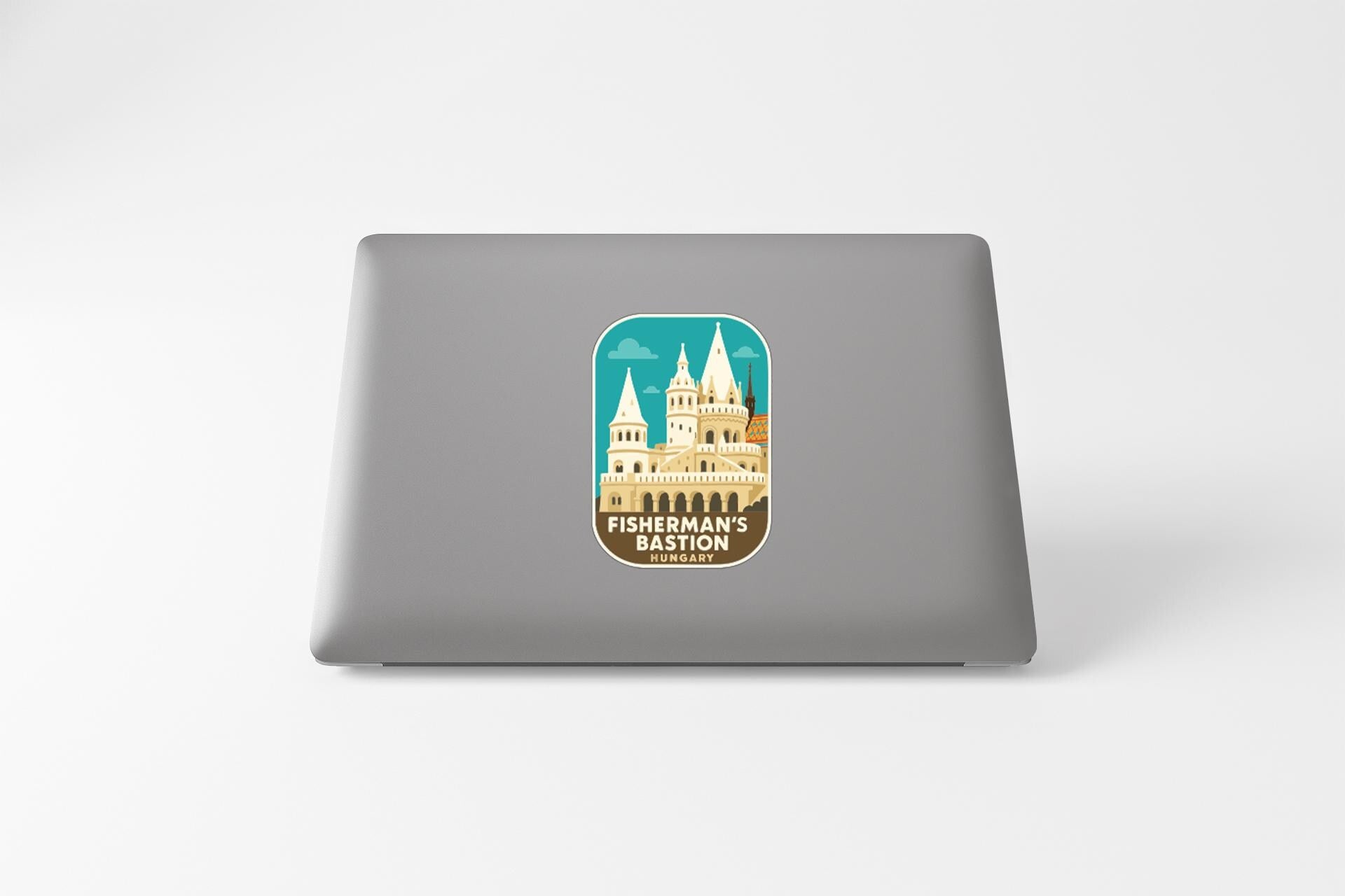 A sticker on the back of a laptop, depicting a castle-like structure.
