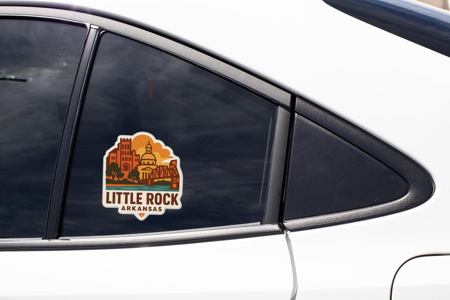 A sticker on the side of a car window, featuring an illustration of a city skyline and the text "Little Rock Arkansas".