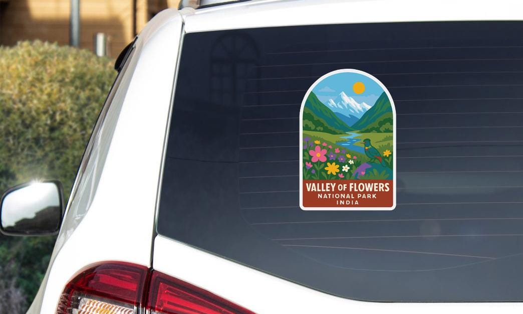 A sticker on the rear window of a car that says "Valley of Flowers National Park, India".