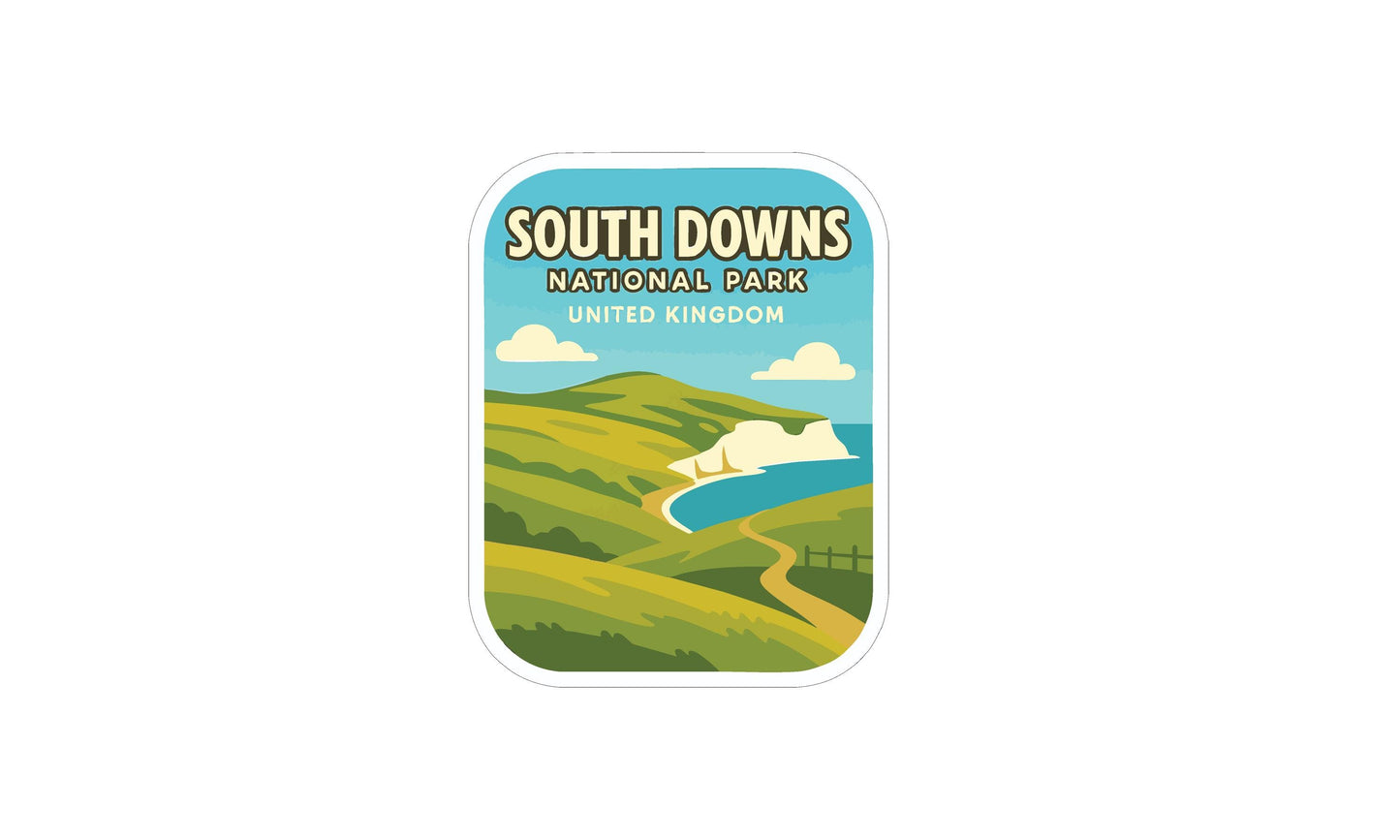 The image is a sticker or label for South Downs National Park in the United Kingdom, featuring a scenic landscape with rolling hills, a winding path, and a body of water.
