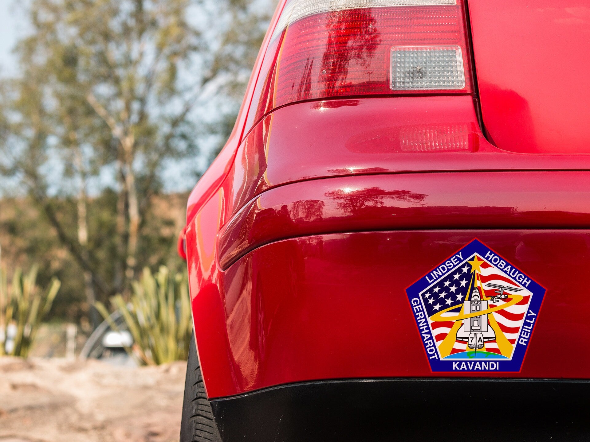a close up of a red car with a sticker on it