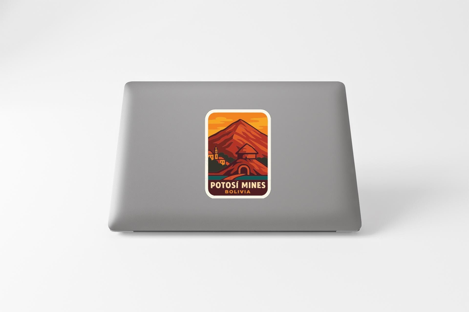 a sticker with a mountain and a building on a laptop.