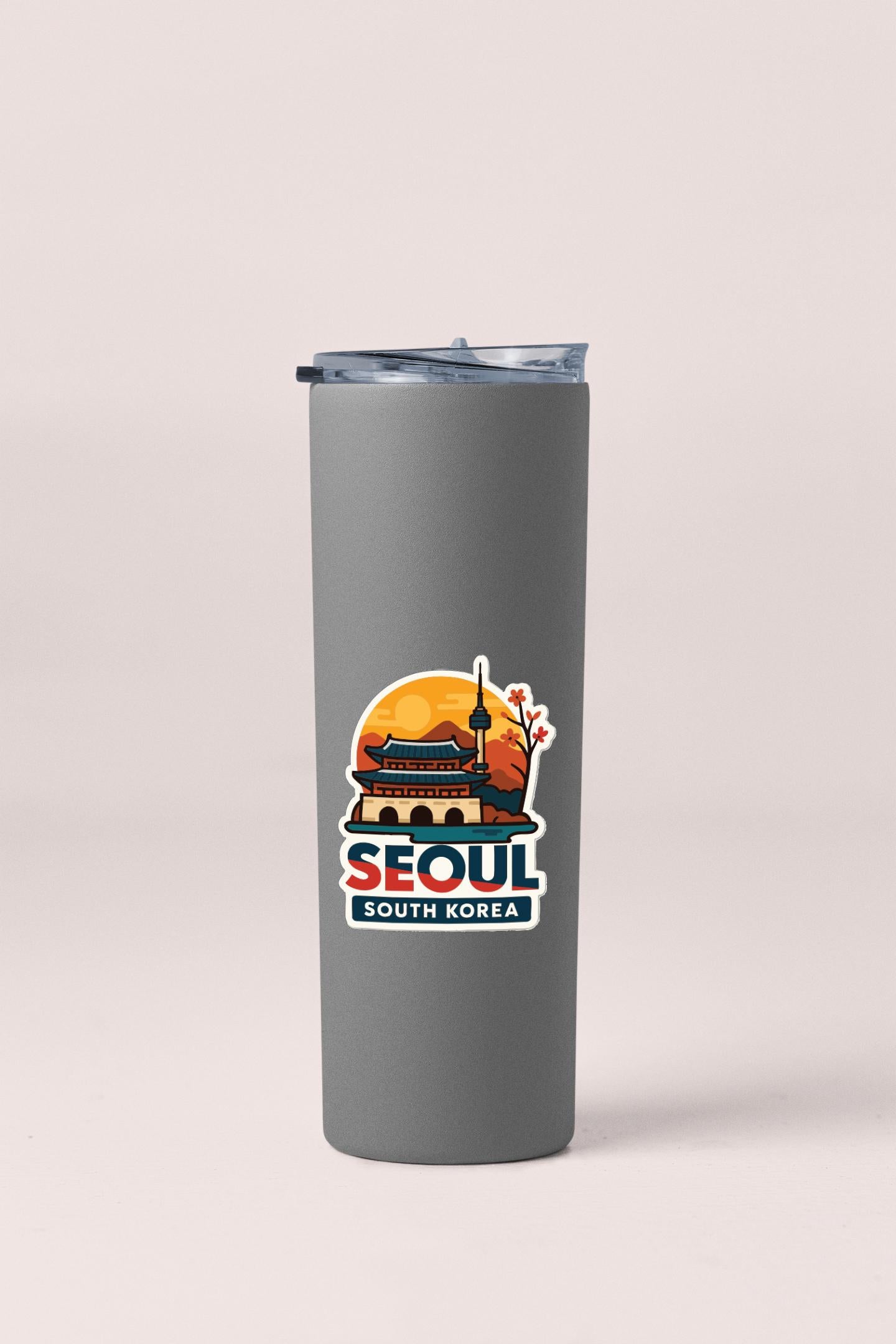A gray insulated tumbler with a printed design of a building and a sunset, along with the text "SEOUL SOUTH KOREA".