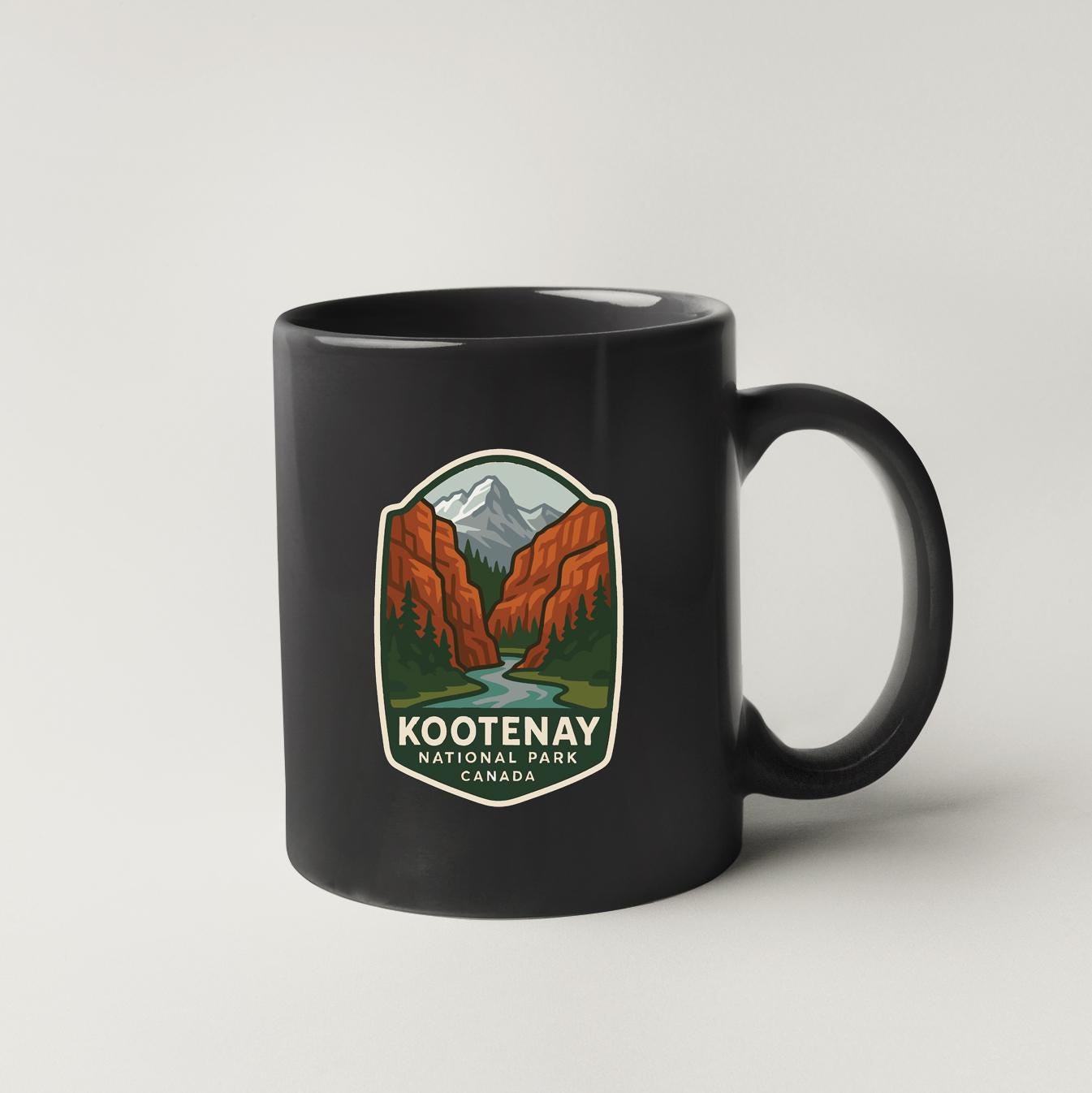 A black coffee mug with a Kootenay National Park Canada logo printed on it.
