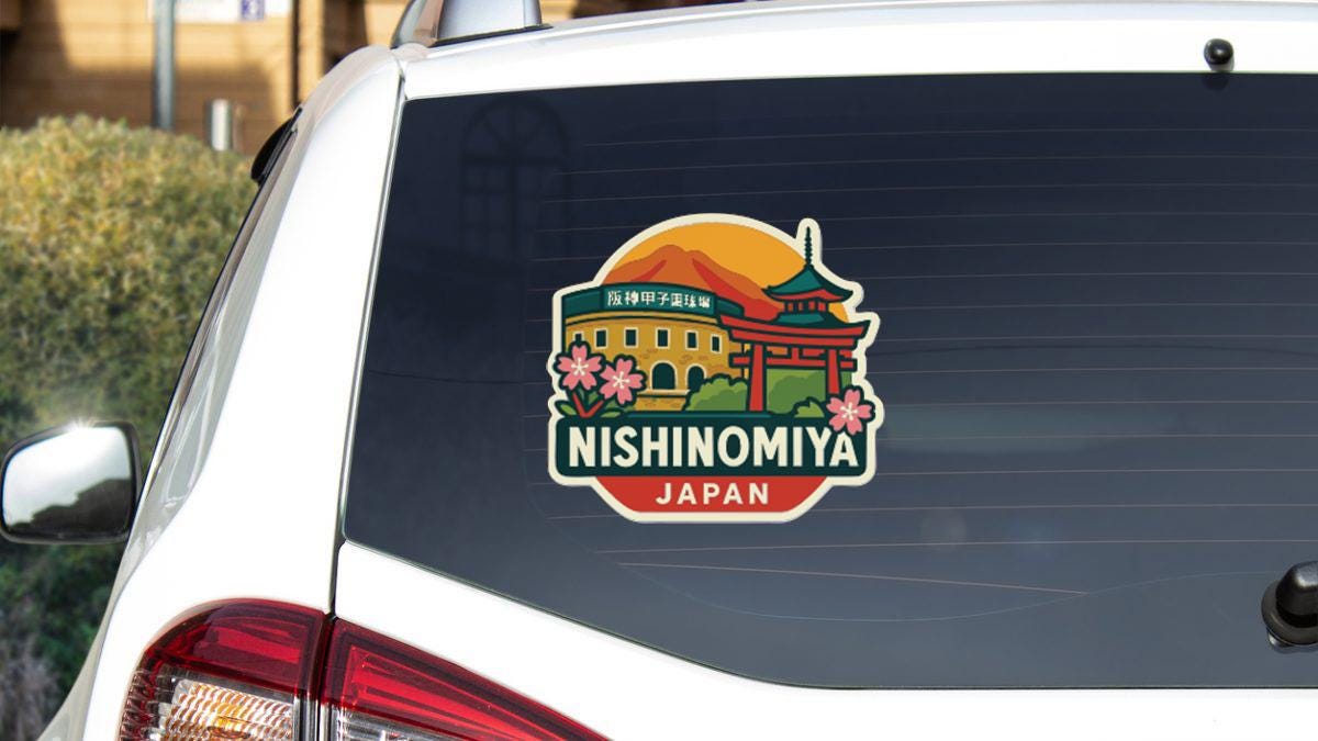 A sticker on the rear window of a car, depicting a temple and mountains, with the text "NISHINOMIYA JAPAN" printed on it.