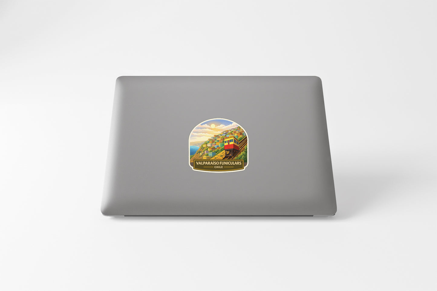 a sticker on the back of a laptop, depicting a scenic landscape with mountains and a train.